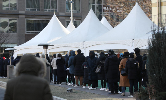 지난달 26일 서울 송파구 보건소 선별진료소에서 시민들이 검사를 기다리고 있다. <연합뉴스>